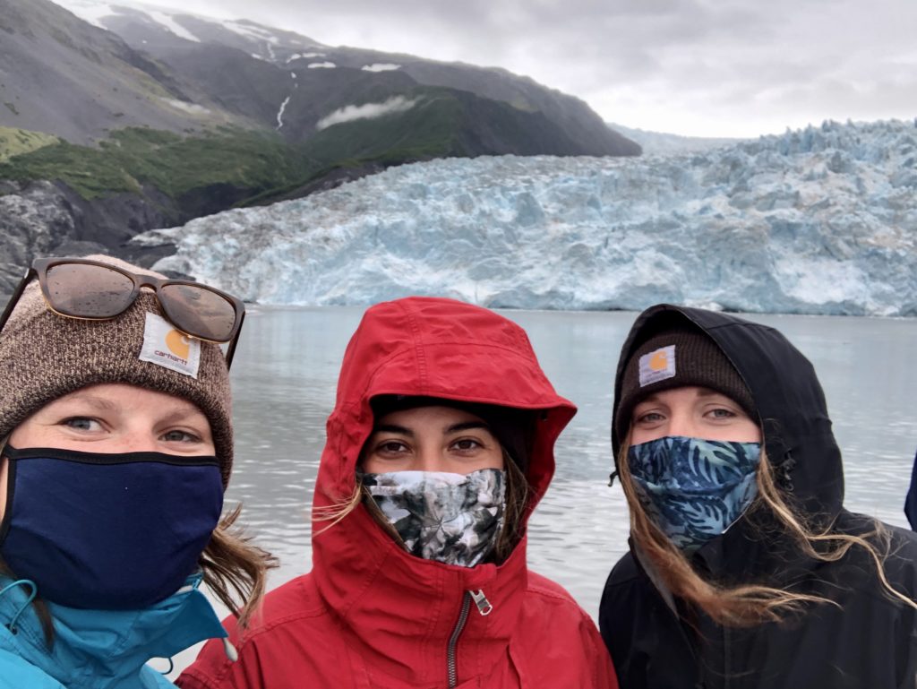 Guests wearing face masks in front of glacier